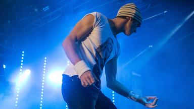 Ein Mann spielt Luftgitarre: Er tut so, als ob er eine Gitarre spielt. 