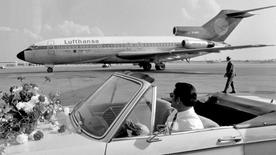 Un conductor espera en la pista de aterrizaje de los jugadores de fútbol de la Bundesliga frente a un avión de Lufthansa en 1970.
