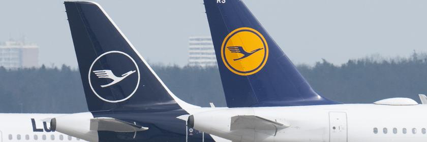 Flugzeuge der Fluggesellschaft Lufthansa stehen auf dem Rollfeld eines Flughafens.
