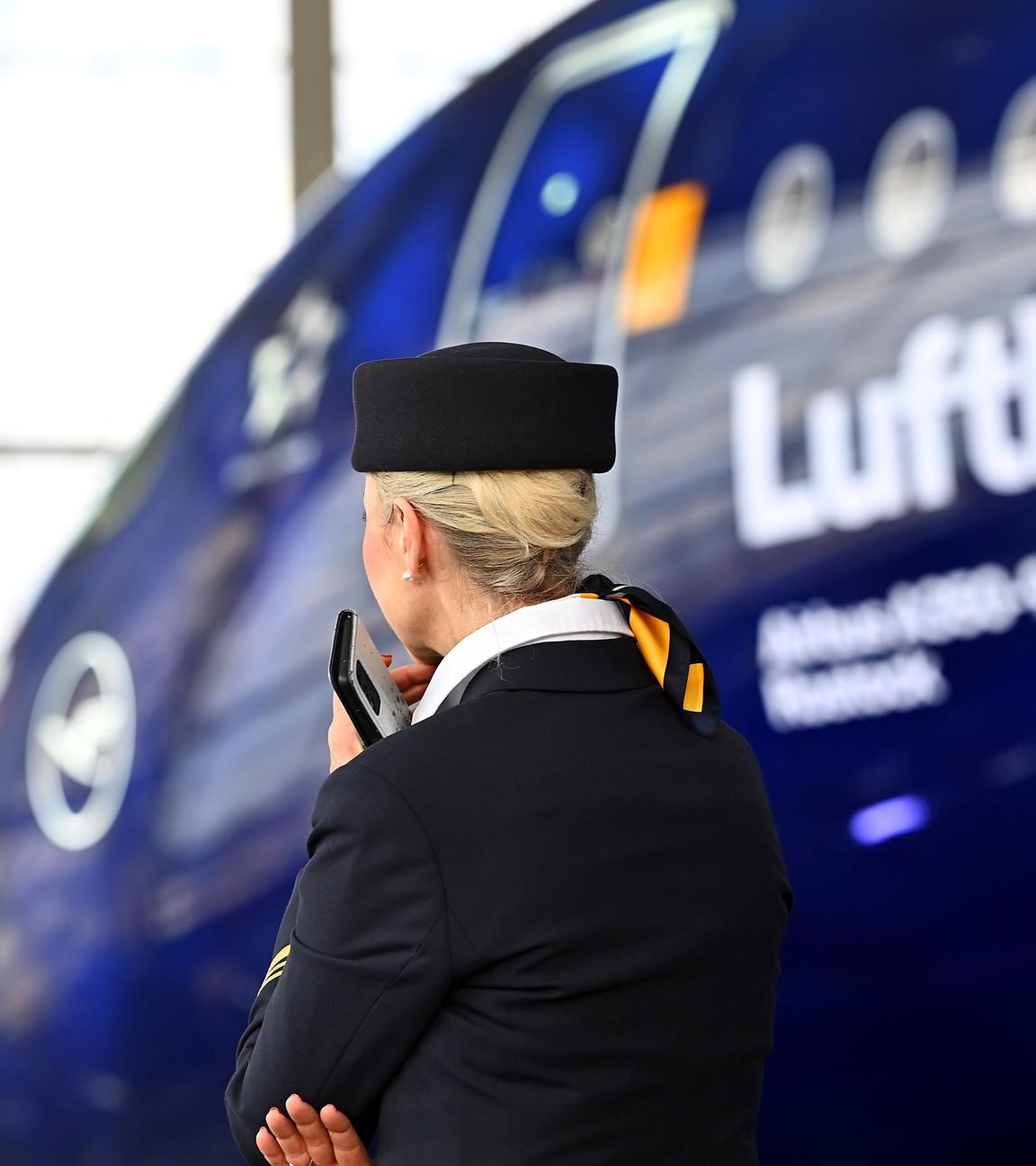 Eine Stewardess vor einem Lufthansa Jet Airbus A350-900