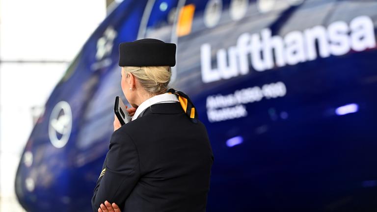 Eine Stewardess vor einem Lufthansa Jet Airbus A350-900