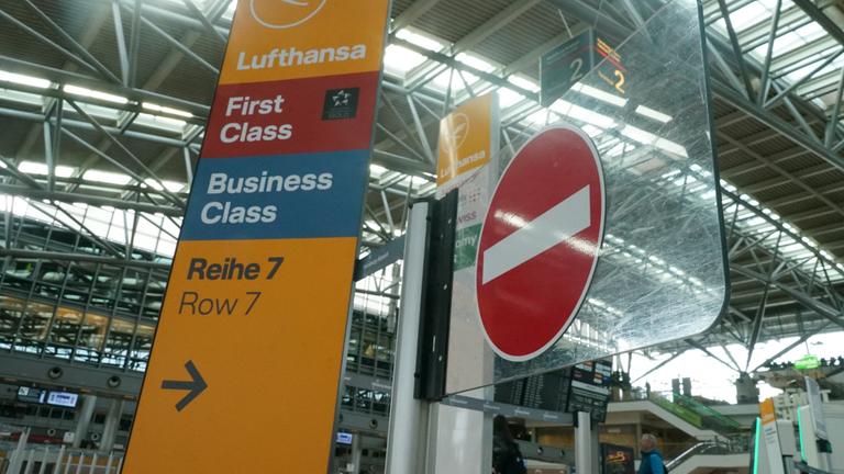 Ein Lufthansa Wegweiser steht neben einem Stopp-Schild am Flughafen Hamburg