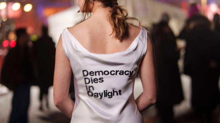 Luisa Neubauer setzt am Abend vor den bundesweiten Streiks fuer Schutz von Klima und Demokratie bei der Berlinale in einem weissen Statement-Kleid ein Zeichen: Donald & Alice & Elon & Friedrich Democracy dies in daylight. 