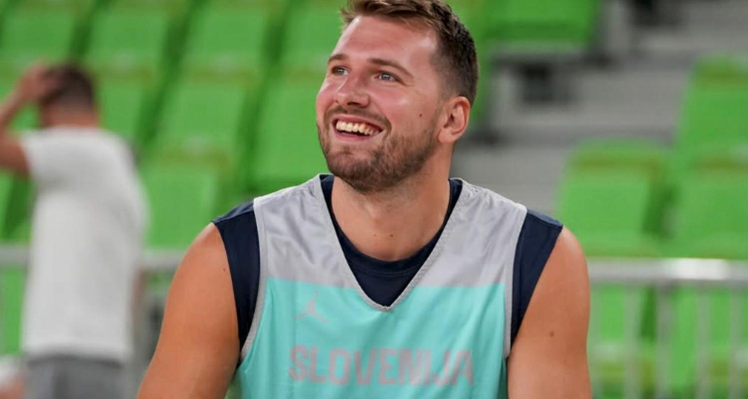 Luka Doncic hält beim Training mit der slowenischen Nationalmannschaft einen Ball in der Hand und lacht