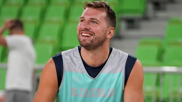 Luka Doncic hält beim Training mit der slowenischen Nationalmannschaft einen Ball in der Hand und lacht