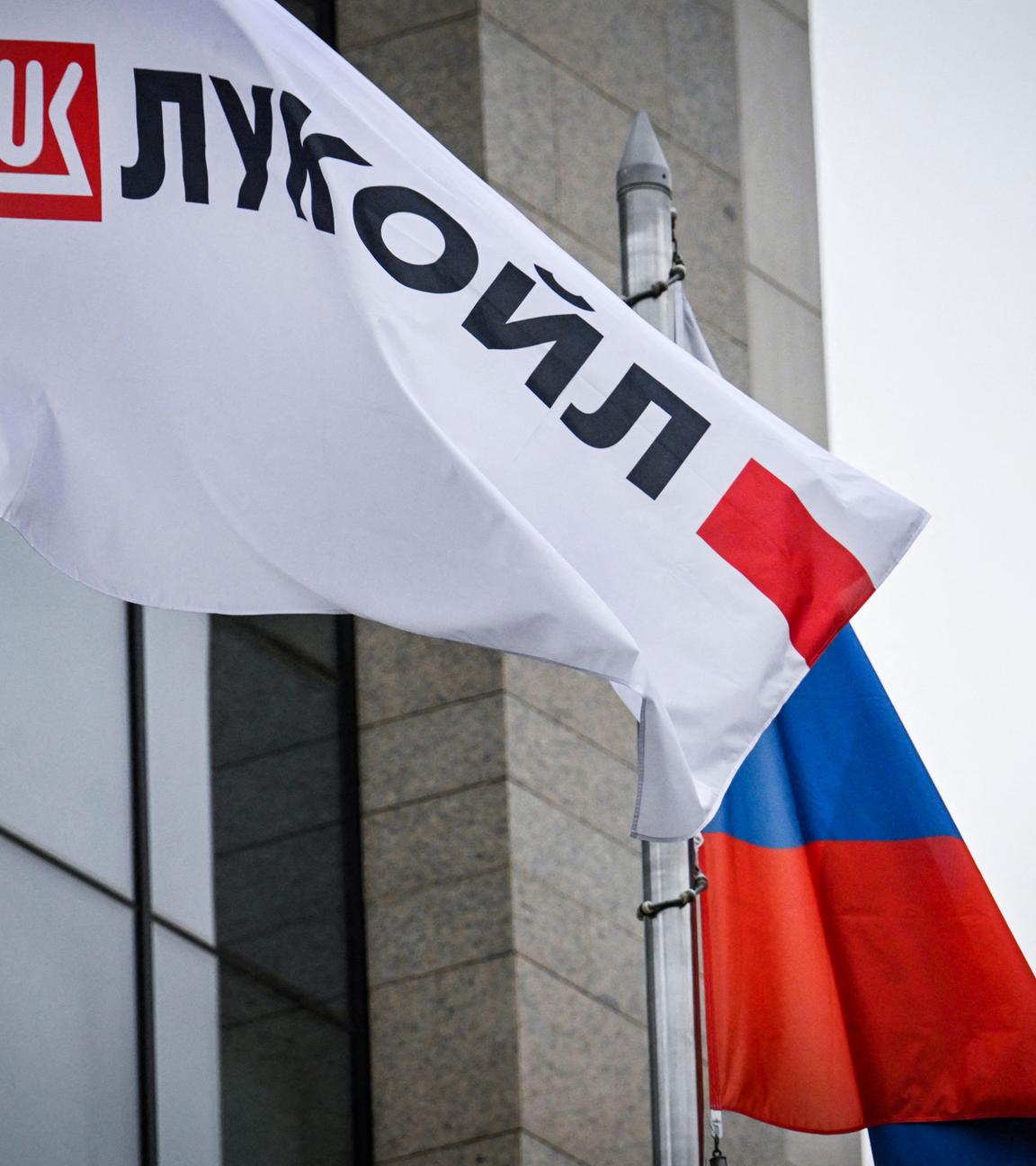 Wehende Logobanner des russischen Ölgiganten Lukoil und eine russische Nationalflagge vor dem Lukoil-Hauptgebäude in Moskau.