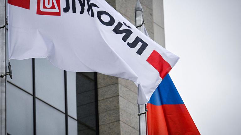 Wehende Logobanner des russischen Ölgiganten Lukoil und eine russische Nationalflagge vor dem Lukoil-Hauptgebäude in Moskau.