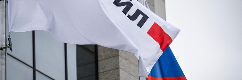 Wehende Logobanner des russischen Ölgiganten Lukoil und eine russische Nationalflagge vor dem Lukoil-Hauptgebäude in Moskau.