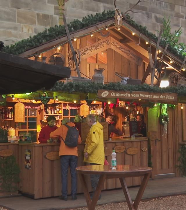Weihnachtsmarktstand mit Menschen davor