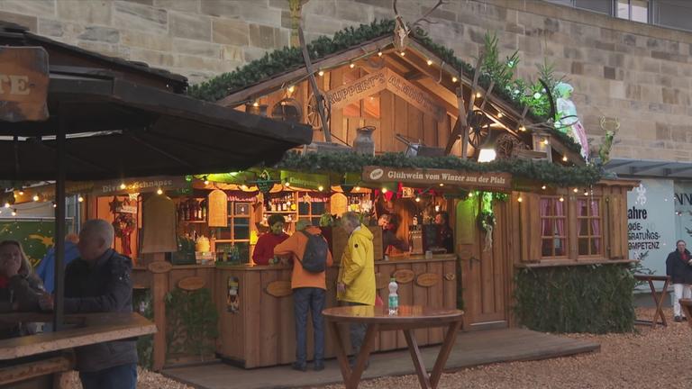 Weihnachtsmarktstand mit Menschen davor