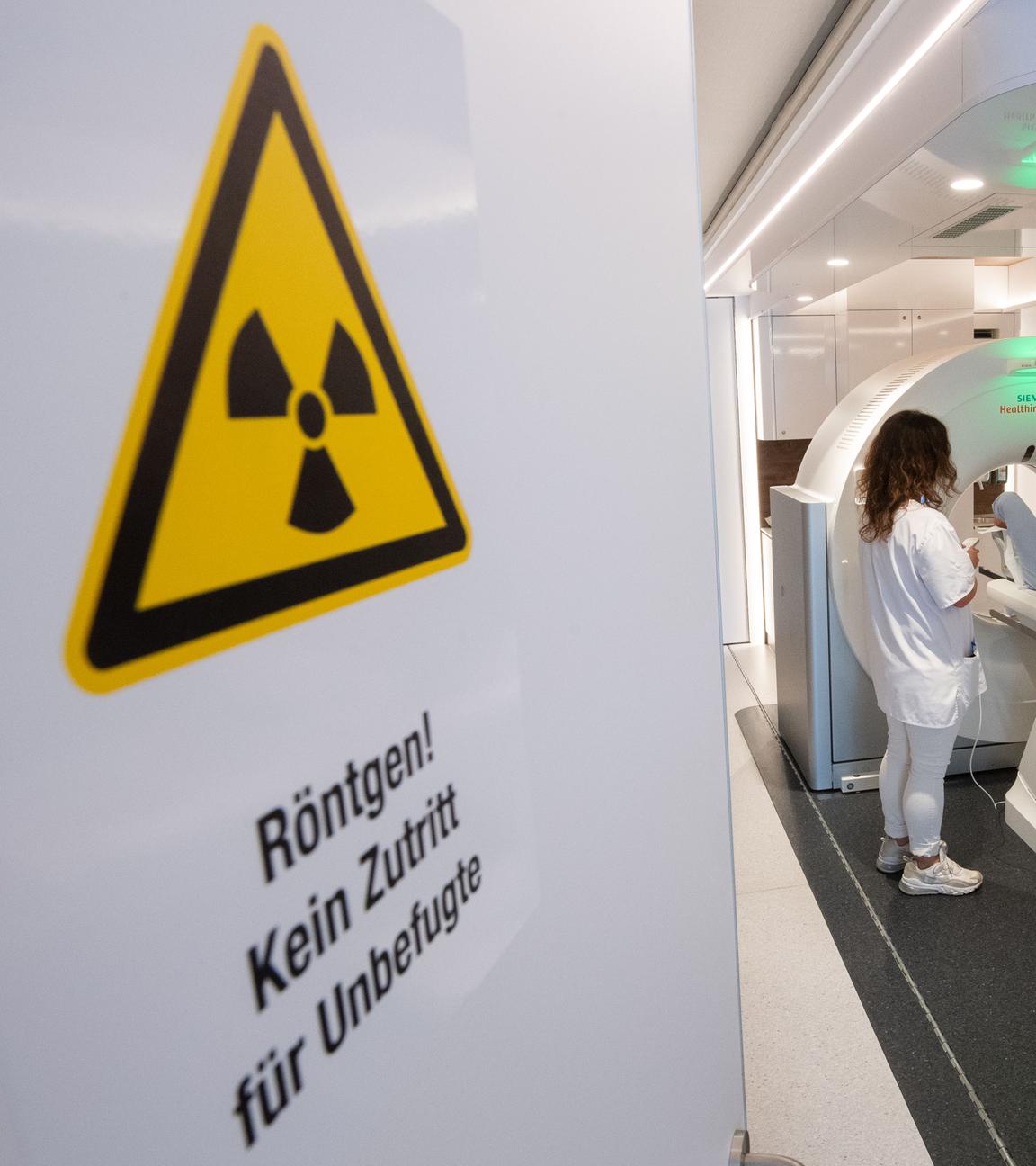 Eine medizinisch-technische Radiologieassistentin, spricht mit einem Mann in einem mobilen Computertomographen CT, bevor er sich einem Lungencheck unterzieht.