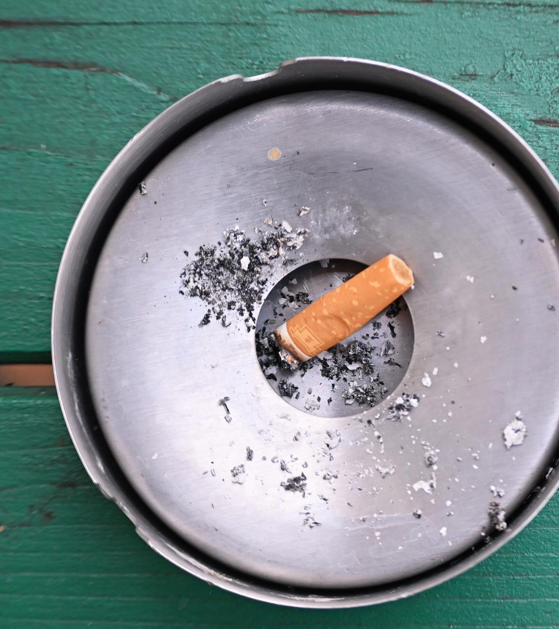 SYMBOLBILD - 27.11.2024, Berlin: Im Freien liegt eine abgebrannte Zigarette in einem Aschenbecher.
