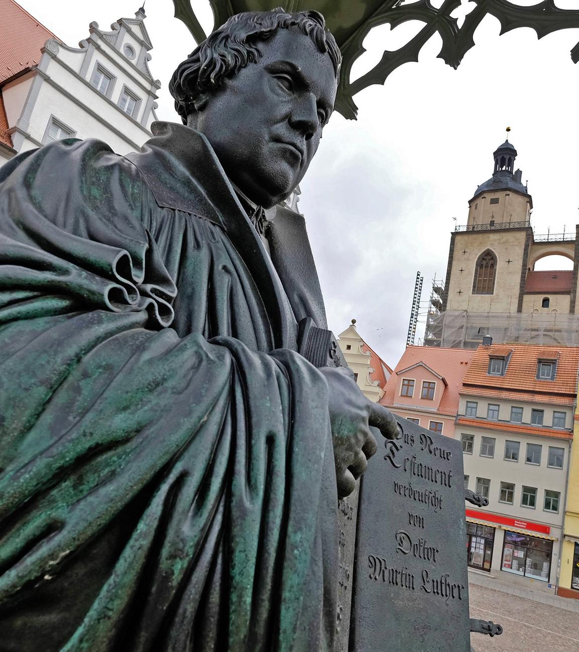 Denkmal des Reformators Martin Luther (1483 - 1546) mit der von ihm ins Deutsche uebersetzten Bibel in der Hand auf dem Marktplatz der Lutherstadt Wittenberg, (Sachsen-Anhalt)