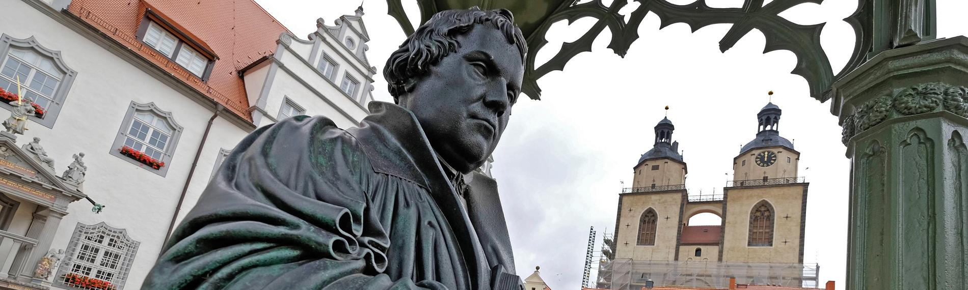 Denkmal des Reformators Martin Luther (1483 - 1546) mit der von ihm ins Deutsche uebersetzten Bibel in der Hand auf dem Marktplatz der Lutherstadt Wittenberg, (Sachsen-Anhalt)