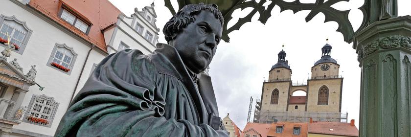 Denkmal des Reformators Martin Luther (1483 - 1546) mit der von ihm ins Deutsche uebersetzten Bibel in der Hand auf dem Marktplatz der Lutherstadt Wittenberg, (Sachsen-Anhalt)
