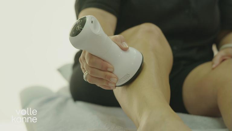 Lymphdrainage-Massage-Gerät wird über Bein gefahren