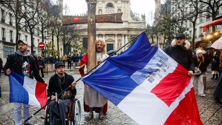 Menschen mit einer französischen Flagge und der Aufschrift „Gerechtigkeit für Quentin“ nehmen an einer Kundgebung zum Gedenken an den in Lyon getöteten 23-jährigen Studenten Quentin teil