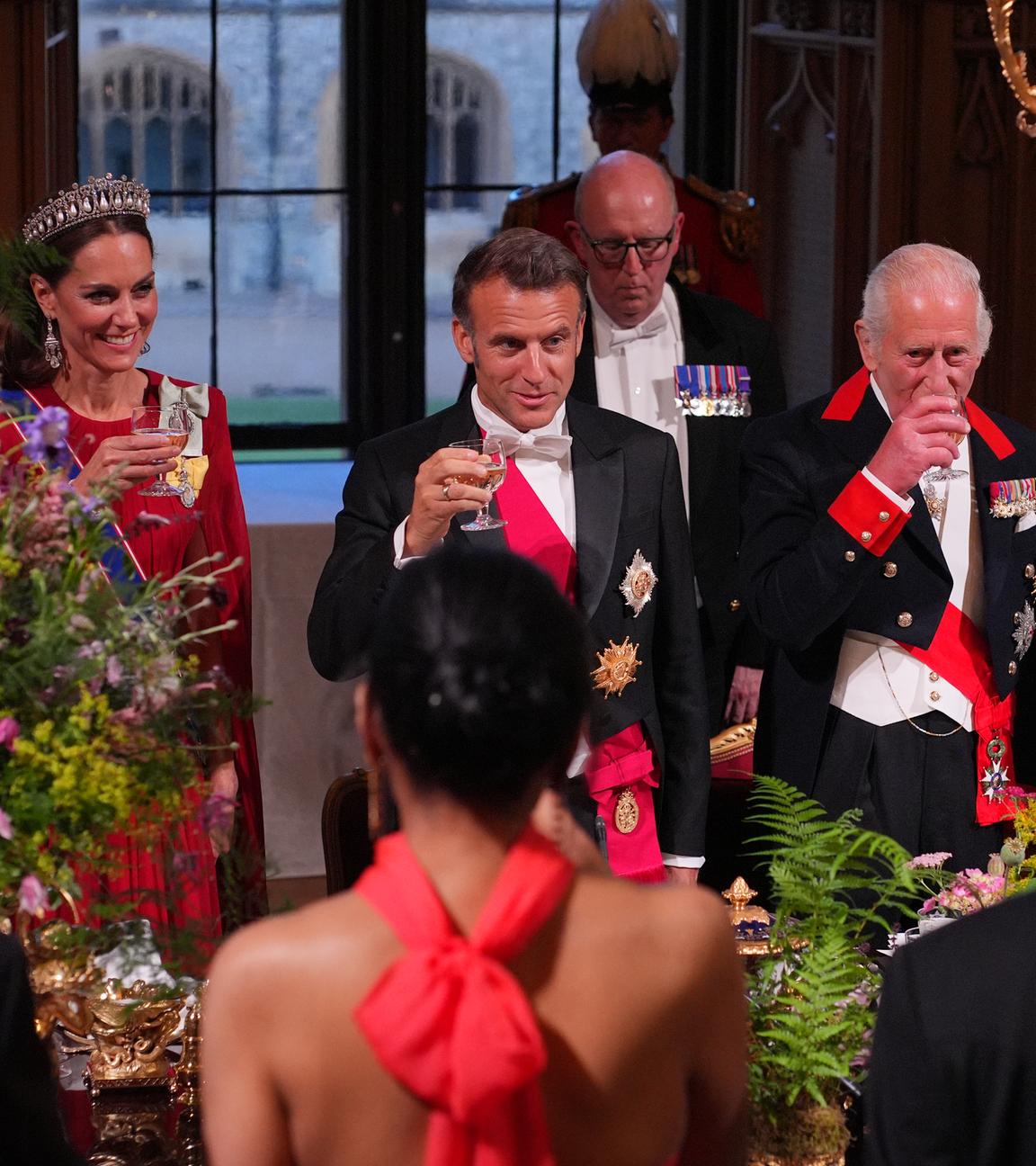 Frankreichs Präsident Macron und der brititsche König Charles stoßen bei einem Essen gemeinsam an. 