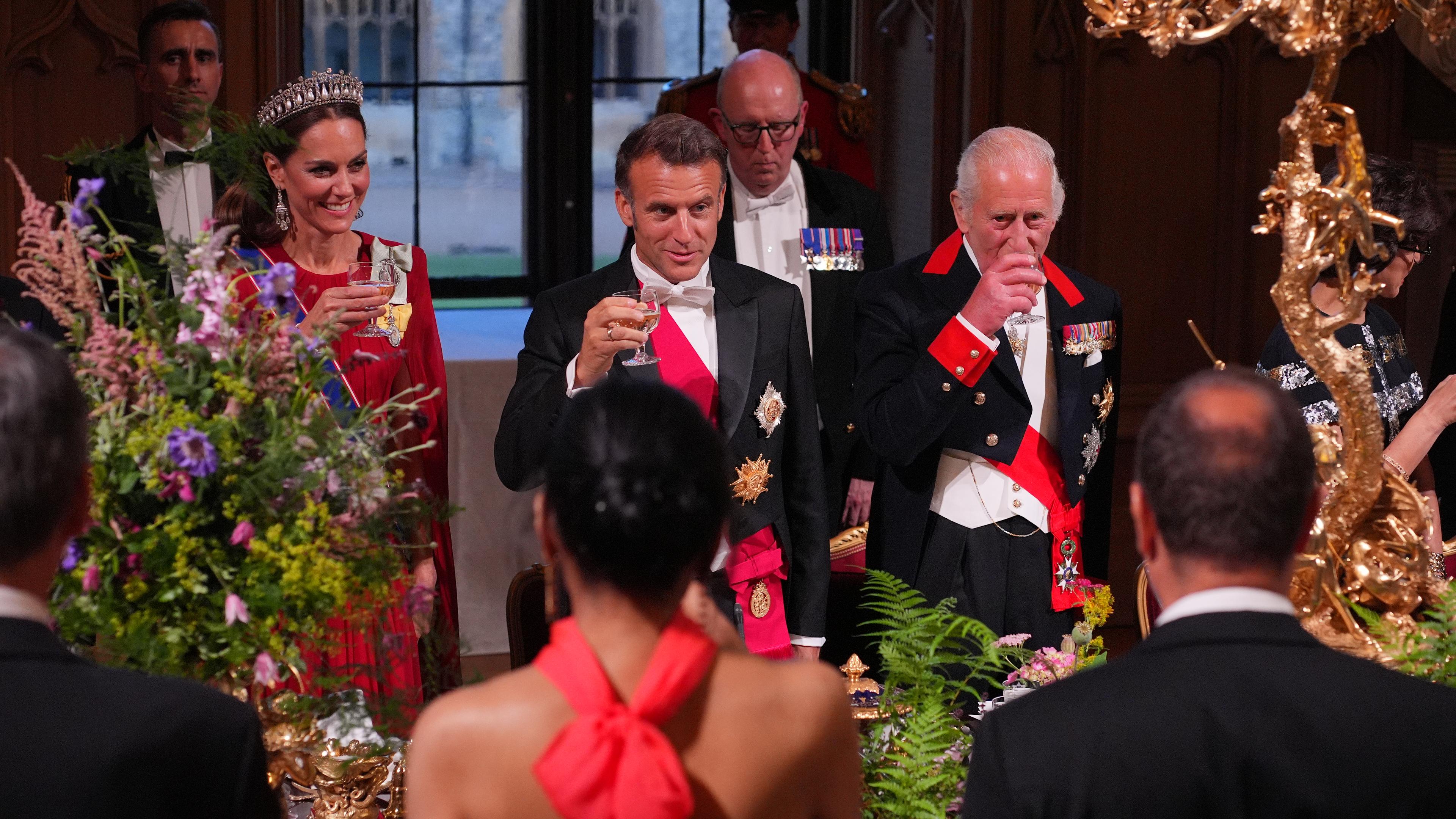 Frankreichs Präsident Macron und der brititsche König Charles stoßen bei einem Essen gemeinsam an. 