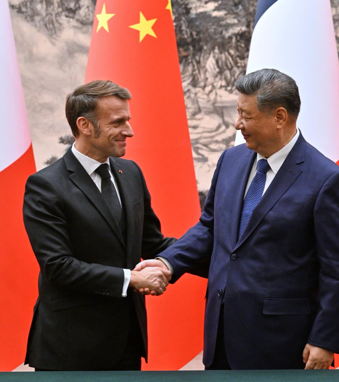 Frankreichs Präsident Emmanuel Macron (l) und Chinas Präsident Xi Jinping geben sich nach einer gemeinsamen Pressekonferenz in der Großen Halle des Volkes die Hand. 