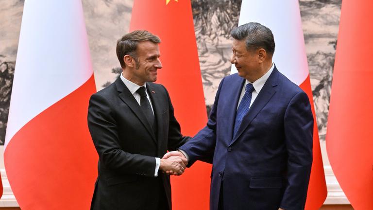 Frankreichs Präsident Emmanuel Macron (l) und Chinas Präsident Xi Jinping geben sich nach einer gemeinsamen Pressekonferenz in der Großen Halle des Volkes die Hand. 