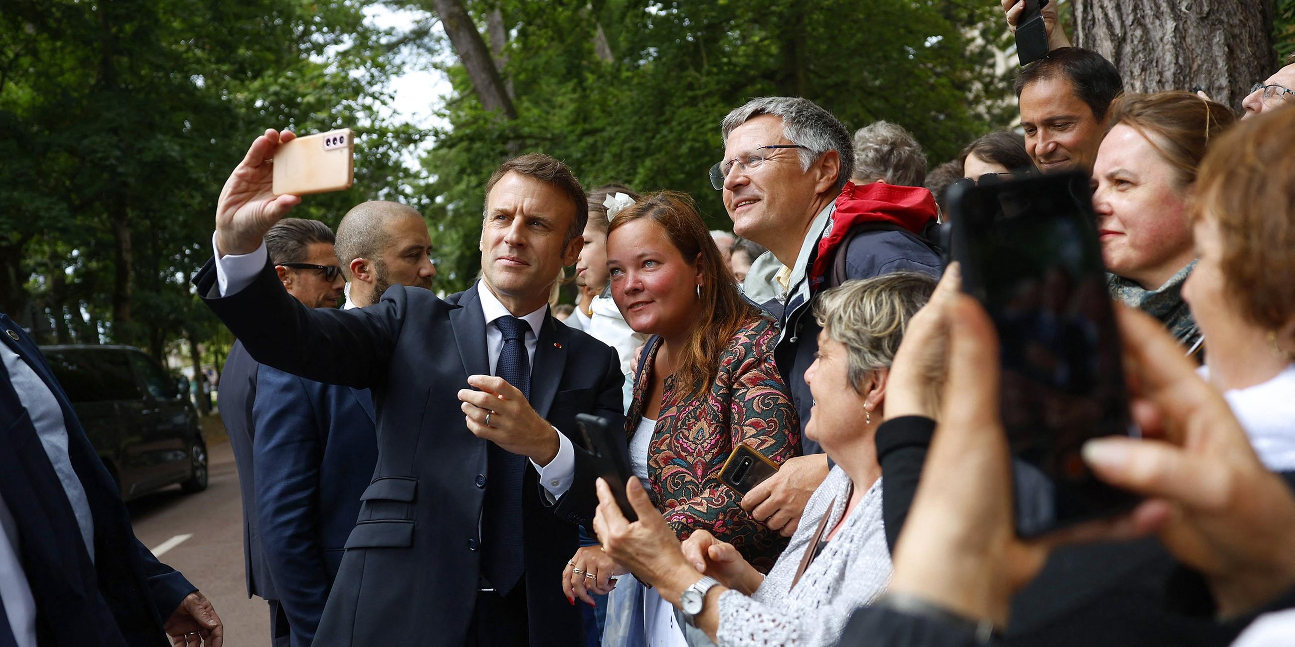 Frankreichs Präsident Emmanuel Macron macht ein Selfie mit Wählern.