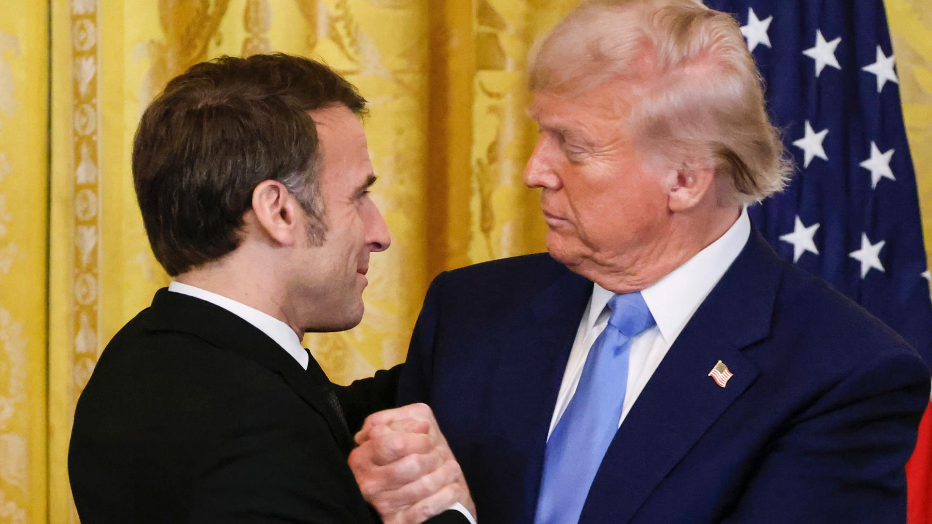 US-Präsident Donald Trump (r) und Frankreichs Präsident Emmanuel Macron schütteln sich nach einer gemeinsamen Pressekonferenz im East Room des Weißen Hauses die Hände.