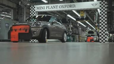 Mini Cooper-Auto in Montagehalle, darüber Schild mit der Aufschrift "Mini Plant Oxford"