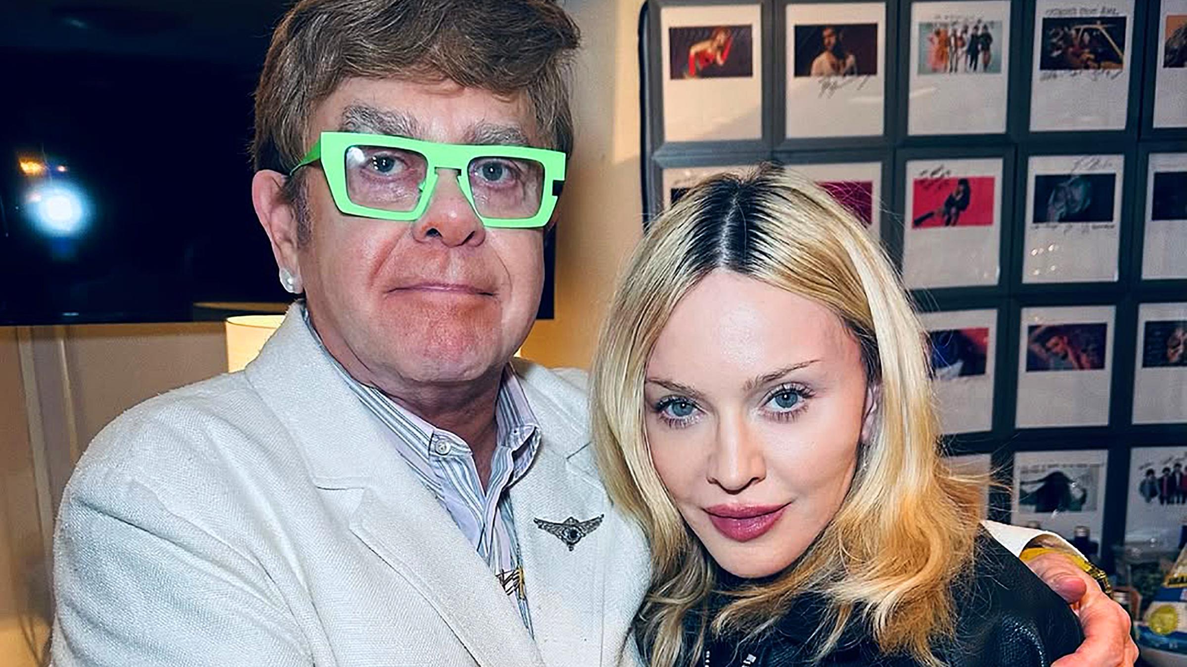 Der Sänger Elton John und die Sängerin Madonna umarmen sich.