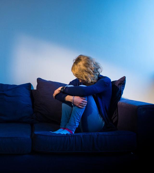 Ein Mädchen auf einem Sofa im Dunkeln