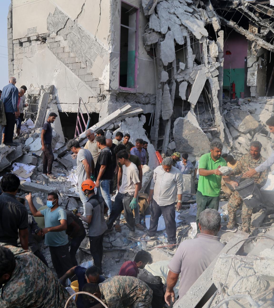 Rettungskräfte und Anwohner durchsuchen am 28.2.2026 die Trümmer nach einem Angriff auf eine Grundschule für Mädchen.
