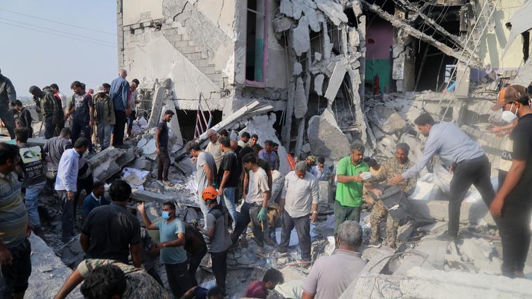 Rettungskräfte und Anwohner durchsuchen am 28.2.2026 die Trümmer nach einem Angriff auf eine Grundschule für Mädchen.