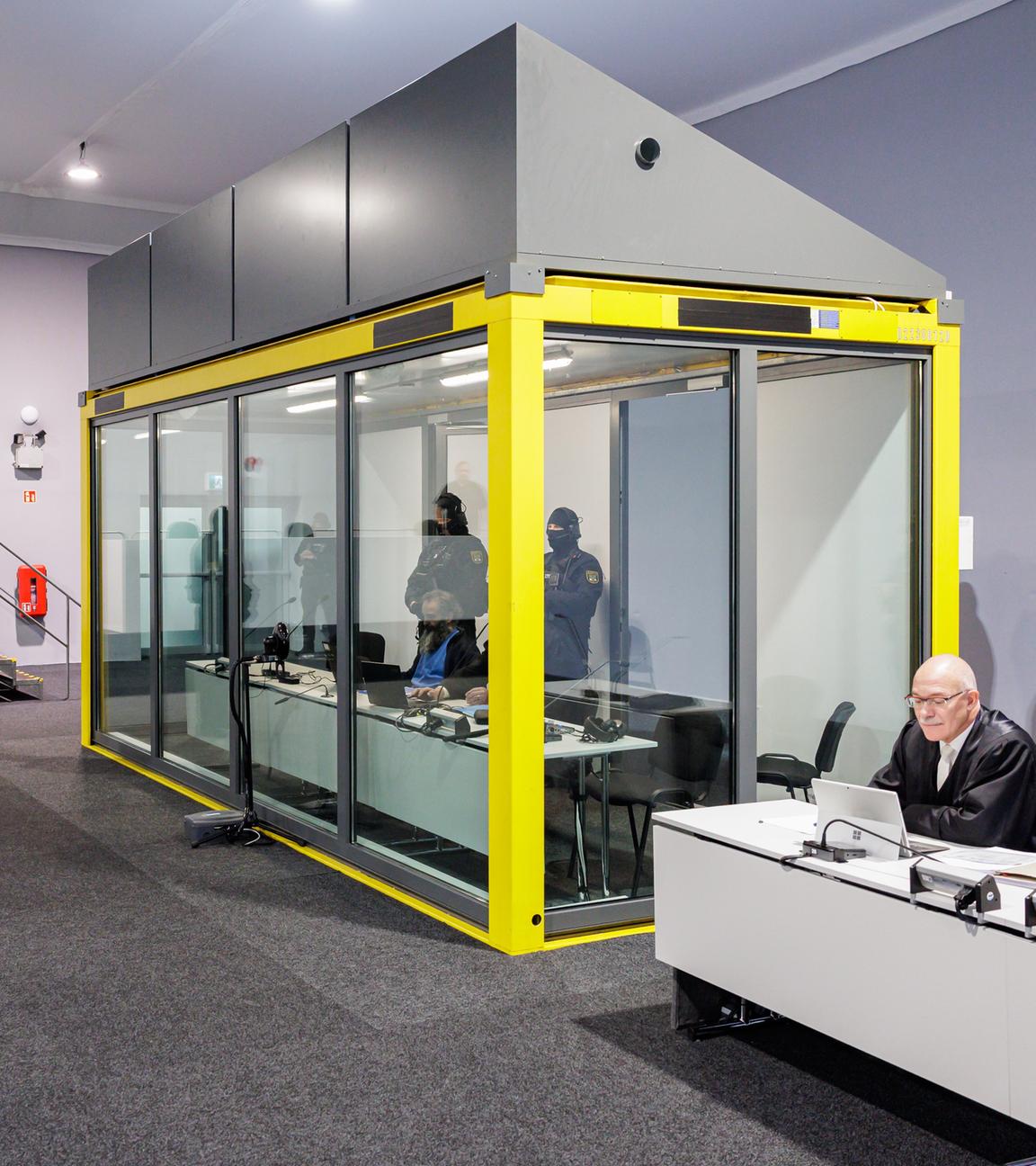 Sicherheitsglaskasten im Gerichtssaal mit bewaffneten Polizisten