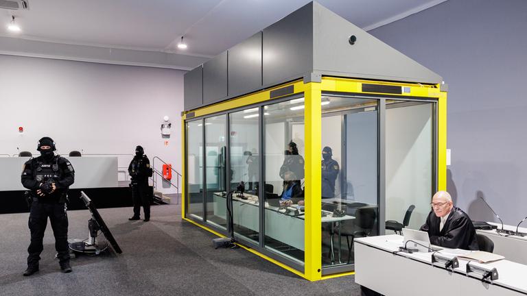 Sicherheitsglaskasten im Gerichtssaal mit bewaffneten Polizisten