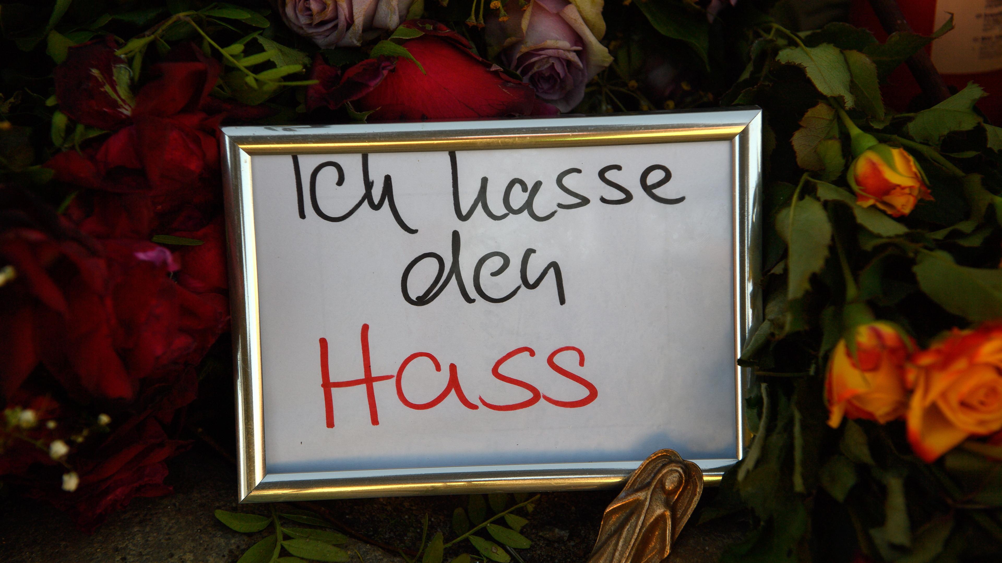Magdeburg: "Ich hasse den Hass" ist am Gedenkort vor der Johanniskirche auf einem Zettel zu lesen der gerahmt in Mitten von Blumen und Kerzen steht.