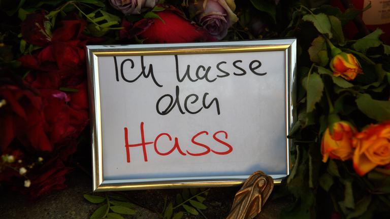 Magdeburg: "Ich hasse den Hass" ist am Gedenkort vor der Johanniskirche auf einem Zettel zu lesen der gerahmt in Mitten von Blumen und Kerzen steht.