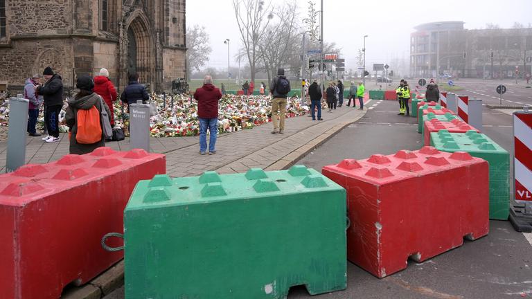 Menschen stehen vor der Johanniskirche, um den Opfern des Anschlags zu gedenken
