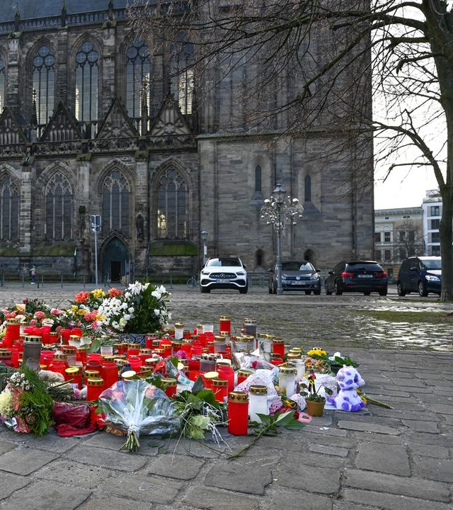 Blumen und Kerzen sind im Gedenken an die Opfer des Anschlags vor dem Magdeburger Dom aufgestellt.