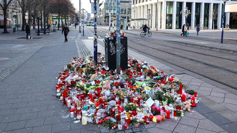 Blumen und Kerzen stehen im Gedenken an die Anschlagsopfer in der Innenstadt von Magdeburg
