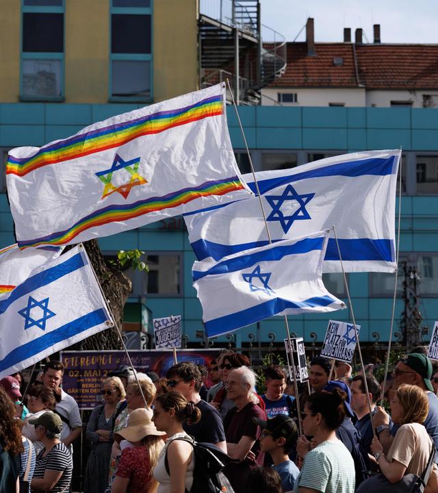 Berlin: Teilnehmer schwenken jüdische Fahnen bei der Mahnwache "Gegen jeden Antisemitismus -Solidarität mit Jüdinnen und Juden" im Berliner Ortsteil Prenzlauer Berg. 
