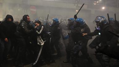Polizisten gehen mit Schlagstöcken gegen Demonstranten vor.