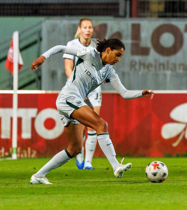 Die Wolfsburgerin Cora Zicai spielt den Ball, bevor ihre Mainzer Gegenspielerin Akari Kurishima eingreifen kann.