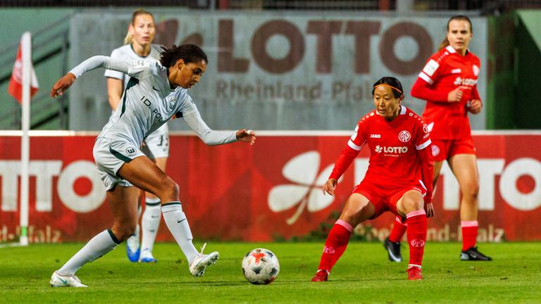 Die Wolfsburgerin Cora Zicai spielt den Ball, bevor ihre Mainzer Gegenspielerin Akari Kurishima eingreifen kann.