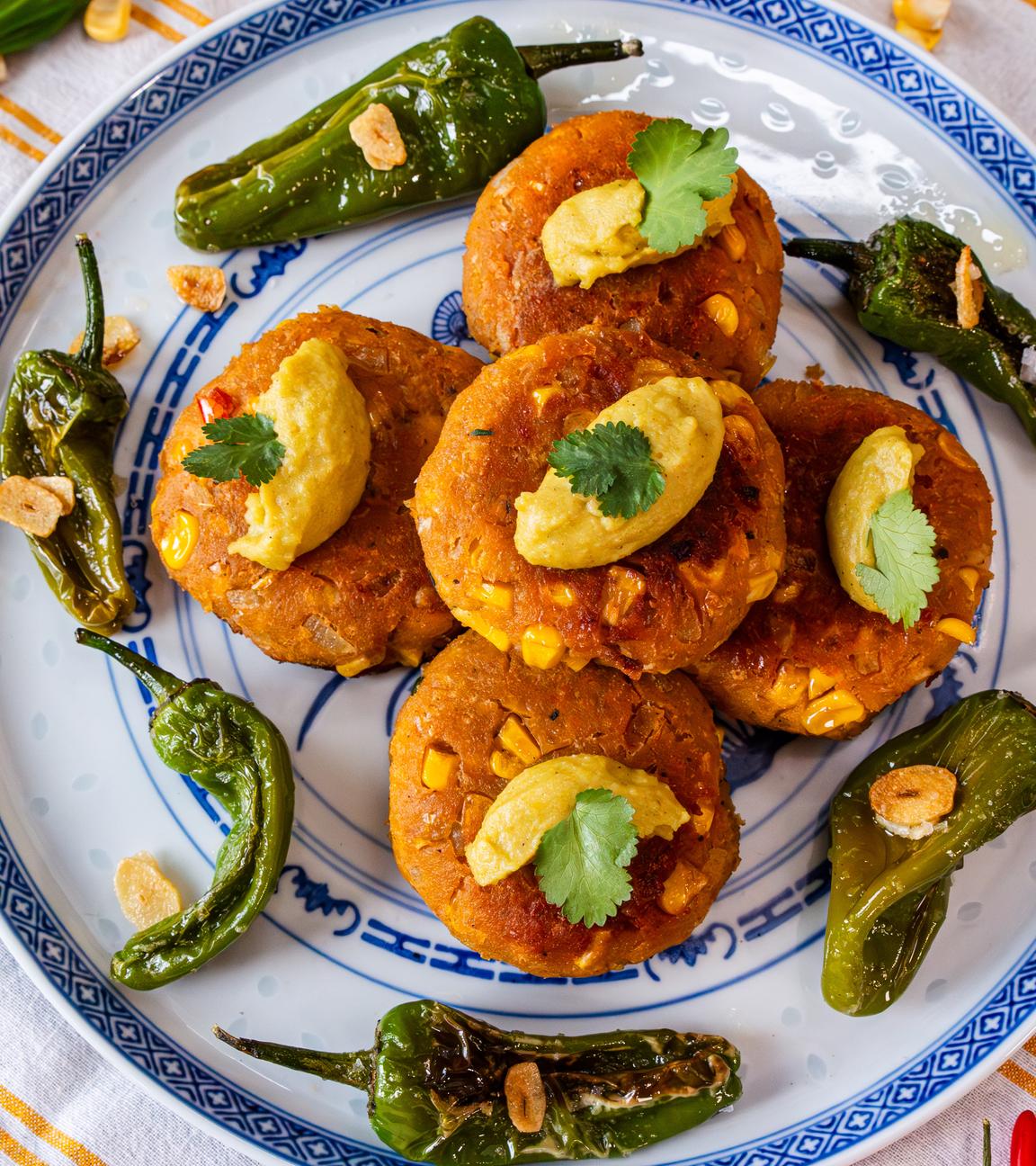Frikadellen aus Mais, getoppt mit Wasabi-Hummus und Bratpaprika an der Seite