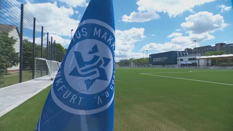 Die Makkabi-Fahne ist im Vordergrund zu sehen, ein Fußballfeld ist im Hintergrund.