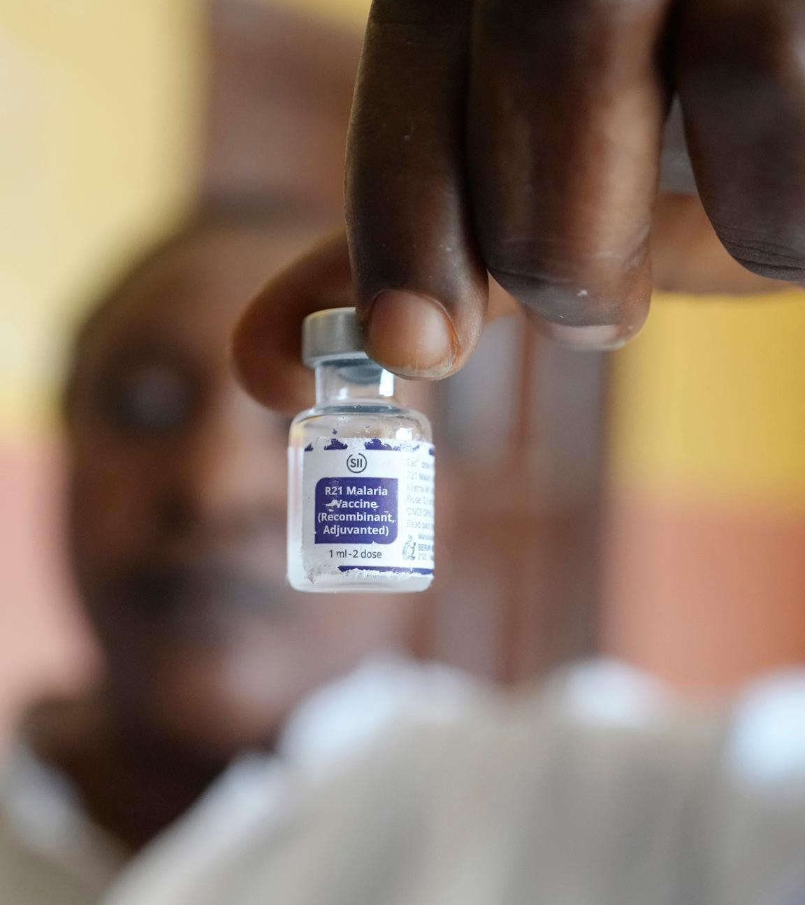 Symbolbild:  Eine Mitarbeiterin des Gesundheitswesens zeigt ein Fläschchen mit dem Malaria-Impfstoff R21/Matrix-M, bevor sie ihn einem Kind im umfassenden Gesundheitszentrum in Agudama-Epie verabreicht. 