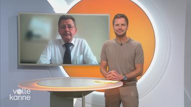 Florian Weiss im VK-Studio mit Prof. Tomas Jelinke im Hintergrund auf dem Bildschirm