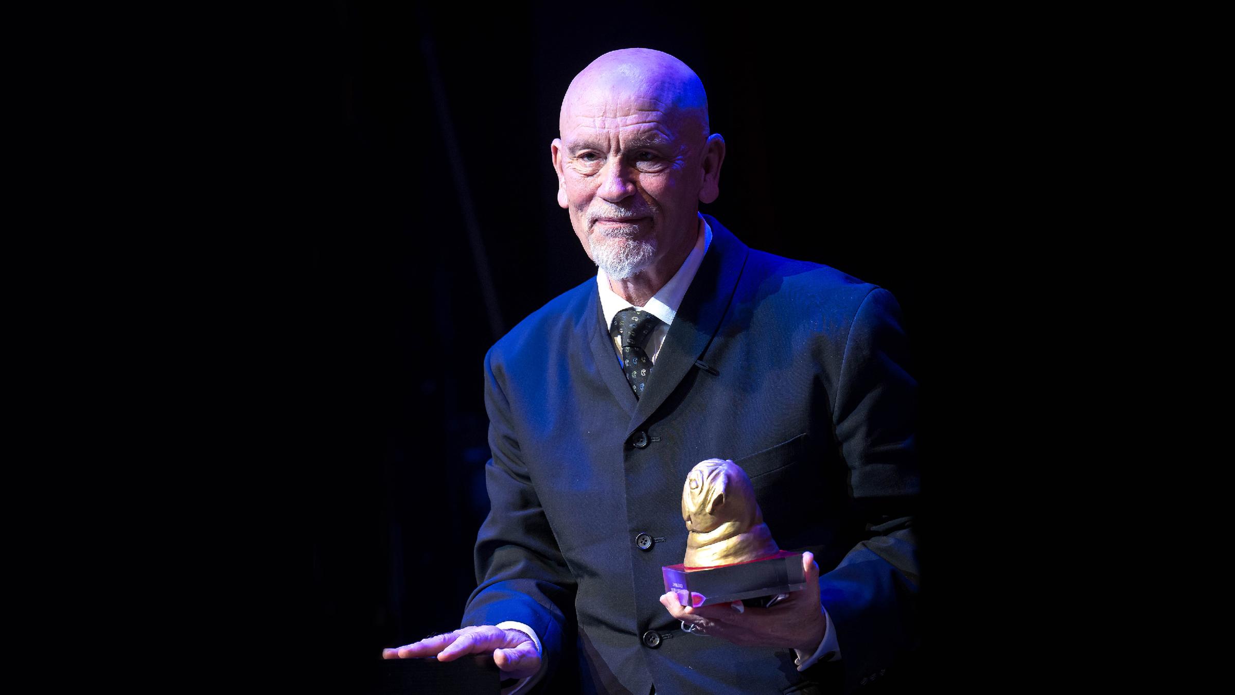 Schauspieler John Malkovich mit dem "Goldenen Mops" in den Händen.