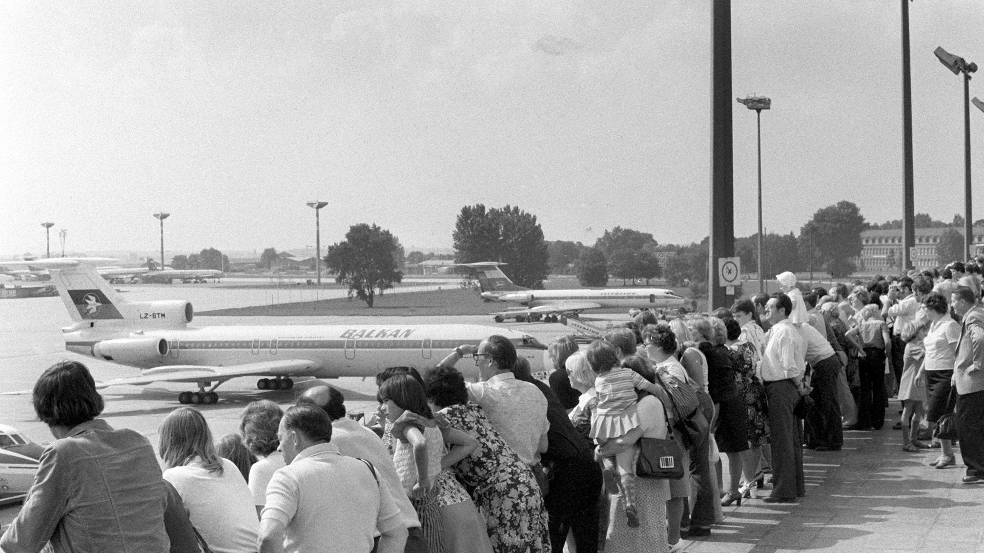 Ostdeutsche schauen bei der Aussichtsterrasse des Zentralflughafens Berlin-Schönefeld bei Ost-Berlin auf Flugzeuge.