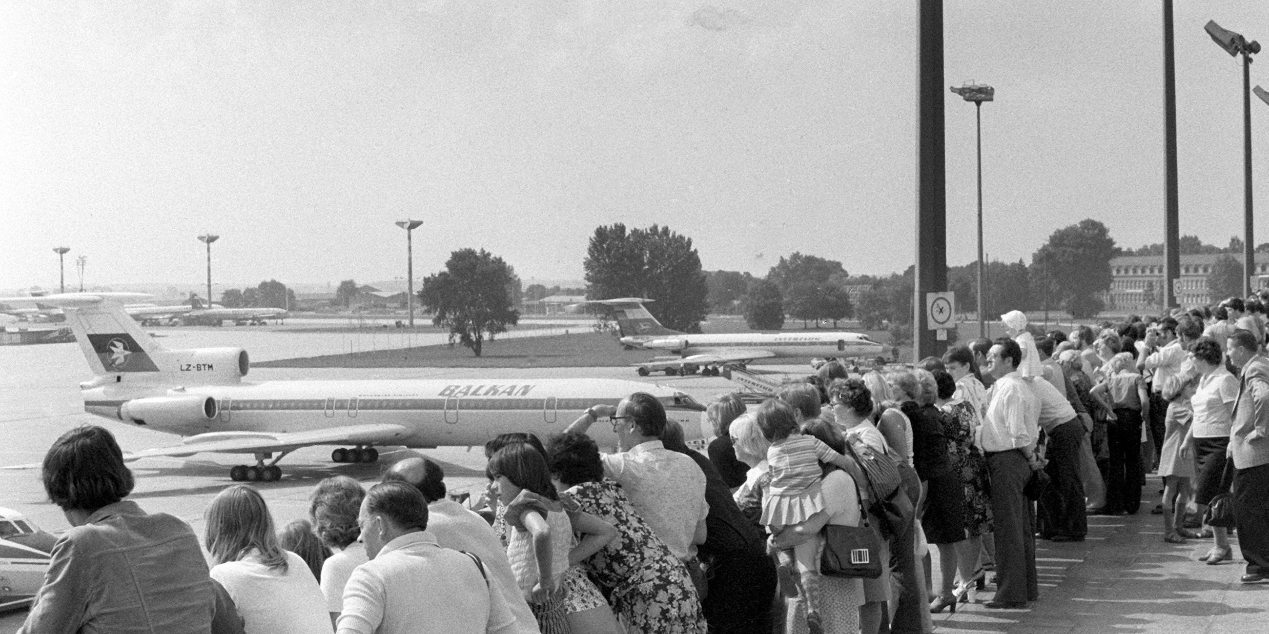 Ostdeutsche schauen bei der Aussichtsterrasse des Zentralflughafens Berlin-Schönefeld bei Ost-Berlin auf Flugzeuge.